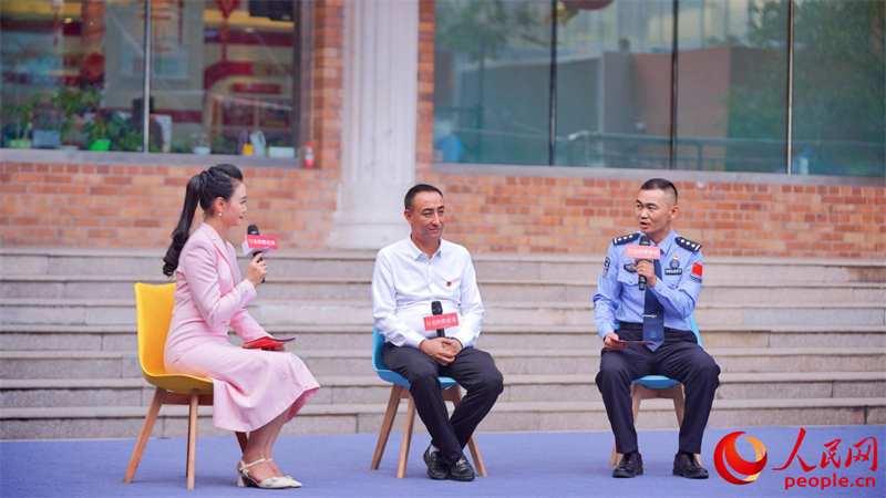 麦麦提热伊木·买买提明（中）、何春明（右一）作交流分享。人民网 李欣洋摄